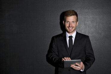 Porträt eines mittleren erwachsenen Mannes mit digitalem Tablet - MAEF006963
