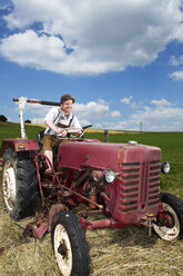 Germany, Bavaria, Farmer in tractor, smiling - MAEF006999