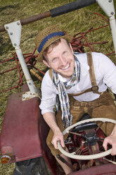 Germany, Bavaria, Portrait of farmer in tractor, smiling - MAEF006986