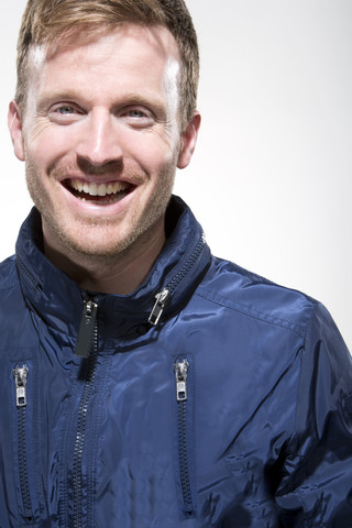 Porträt eines mittleren Erwachsenen in blauer Jacke, lächelnd, Nahaufnahme, lizenzfreies Stockfoto