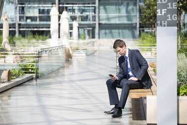 Germany, Hannover, Businessman using smart phone - KFF000201