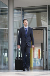 Germany, Hannover, Businessman walking with briefcase at terminal - KFF000082