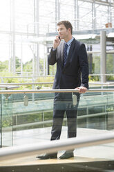 Germany, Hannover, Businessman talking on mobile phone - KFF000185