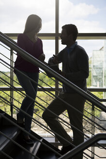 Deutschland, Hannover, Geschäftsleute stehen auf einer Treppe mit digitalem Tablet - KFF000109