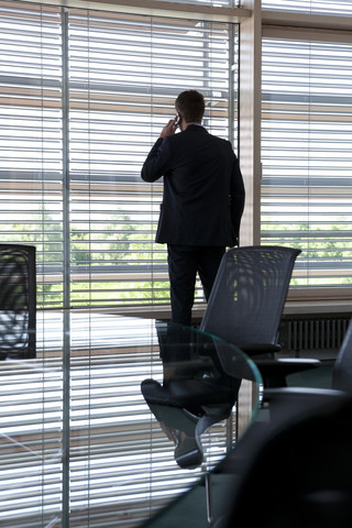 Geschäftsmann im Büro am Fenster, lizenzfreies Stockfoto