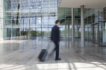 Businessman on the go pulling suitcase - KFF000122