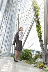 Businesswoman standing in modern courtyard - KFF000162