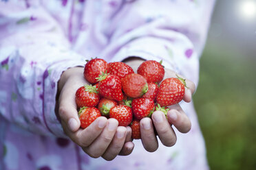 Deutschland, Nordrhein-Westfalen, Köln, Mädchen hält Erdbeeren in den Händen, Nahaufnahme - FMKYF000503