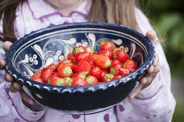 Deutschland, Nordrhein-Westfalen, Köln, Mädchen hält Schale mit Erdbeeren, Nahaufnahme - FMKYF000502