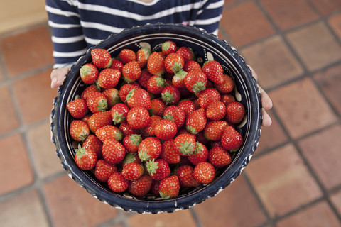 Deutschland, Nordrhein-Westfalen, Köln, Mädchen hält Schale mit Erdbeeren, Nahaufnahme, lizenzfreies Stockfoto