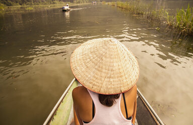 Vietnam, Ninh Binh, Female tourist at tour rowing boat - MBEF000607