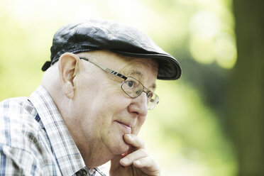 Deutschland, Nordrhein-Westfalen, Köln, älterer Mann mit Mütze und Brille im Park, Nahaufnahme - JAT000122