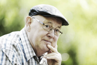 Germany, North Rhine Westphalia, Cologne, Senior man with cap and glasses in park, close up - JAT000123