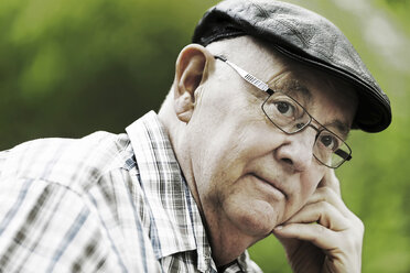 Germany, North Rhine Westphalia, Cologne, Senior man with cap and glasses in park, close up - JAT000131