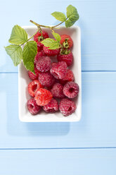 Bowl filled with raspberries on table, close up - MAEF007027