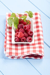Raspberries in bowl on napkin, close up - MAEF007025