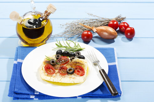 Feta, Tomaten, Oliven und Rosmarin mit einer Gabel in einen Teller geben - MAEF007021