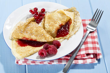 Pancakes with raspberry-jam, raspberries and fresh lowbush cranberries in plate - MAEF007014