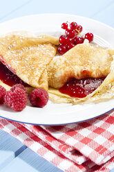 Pfannkuchen mit Himbeermarmelade, Himbeeren und frischen Lowbush Cranberries im Teller - MAEF007013