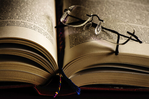 Opened book with bookmark and reading glasses - MOF000192