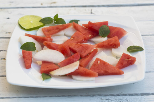 Salat mit Wassermelone und Rettich auf weißem Teller und weißem Holztisch - SARF000084