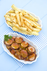 Schüssel mit Würstchen mit Pommes frites, Currywurst und Ketchup auf Holztisch, Nahaufnahme - MAEF007107