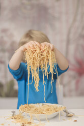 Deutschland, Sachsen, Junge hält Spaghetti in den Händen - MJF000289