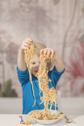 Deutschland, Sachsen, Junge hält Spaghetti in den Händen - MJF000294