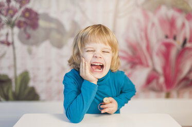 Germany, Saxony, Boy sitting at table, smiling - MJF000297