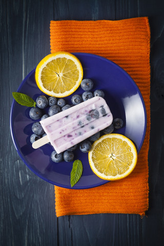 Blaubeer-Joghurt-Bonbon mit Orangenscheiben auf einem Teller, Nahaufnahme, lizenzfreies Stockfoto