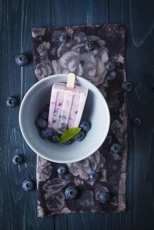 Schale mit Blaubeerjoghurt und Süßigkeiten auf Holztisch, Nahaufnahme - EC000275