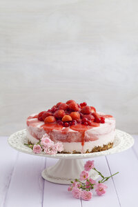 Erdbeerkäsekuchen mit frischen Erdbeeren und roten Johannisbeeren auf Holztisch, Nahaufnahme - ECF000294