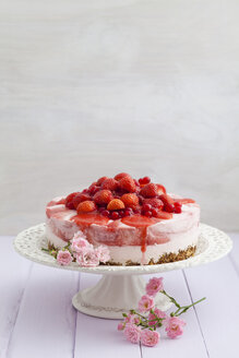 Erdbeerkäsekuchen mit frischen Erdbeeren und roten Johannisbeeren auf Holztisch, Nahaufnahme - ECF000294