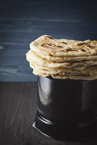 Stack of flat breads on wooden table, close up - EC000296