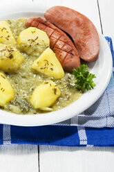 Grünkohl mit Wurst und Kartoffeln im Teller, Nahaufnahme - MAEF007031
