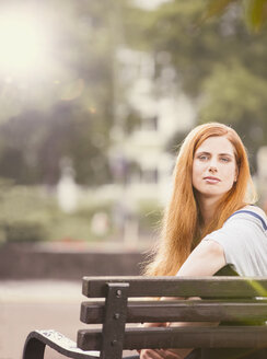 Germany, Berlin, Portrait of woman sitting on bench - ZMF000013