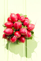 Bunch of red radishes on wooden table, close up - MAEF007060