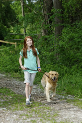 Germany, Bavaria, Girl with dog walking - LB000254