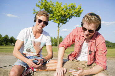 Germany, two young men wearing head phones, listening to music - GDF000153