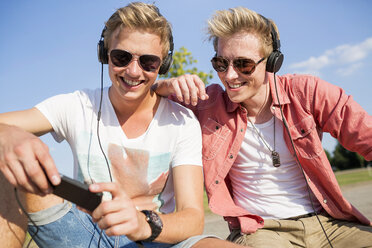 Deutschland, zwei junge Männer mit Kopfhörern, die Musik hören - GDF000155