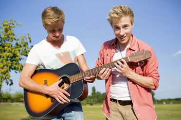 Deutschland, Zwei Freunde spielen Gitarre im Park - GDF000162