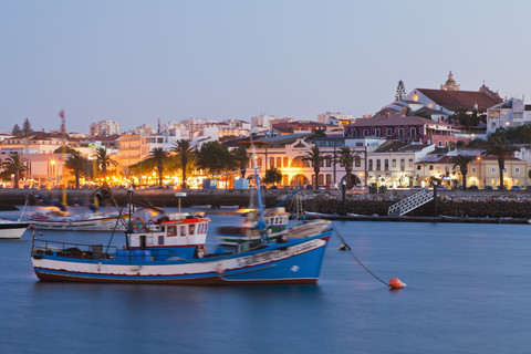 Portugal, Lagos, View of fishing boat at harbour and city in background stock photo