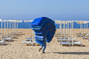 Portugal, Albufeira, Vorbereiten von Strandliegen am Morgen - WD001760