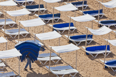 Portugal, Albufeira, Vorbereiten von Strandliegen am Morgen - WD001759