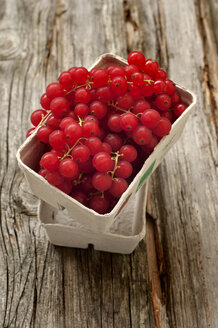 Cardboard box filled with red currants on table, close up - OD000280