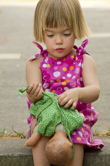 Germany, Baden Wuerttemberg, Girl dresing her doll - LVF000187