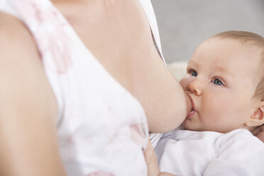 Germany, North Rhine Westphalia, Cologne,Mother breastfeeding her daughter, close up - PDF000389