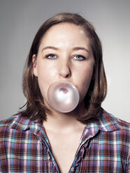 Portrait of Young woman blowing bubble gum - STKF000301