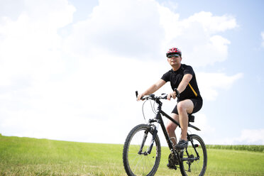 Germany, Bavaria, Mature man riding mountain bike - MAEF007147