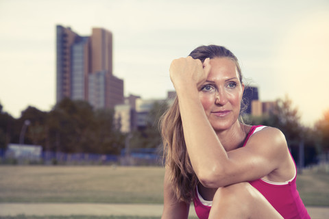 Sportliche reife Frau sitzt im Park, lizenzfreies Stockfoto